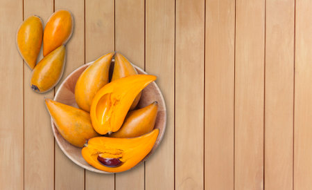Lucuma fruit in wooden bow with space on wooden table background, tropical and healthy diet fruitの写真素材