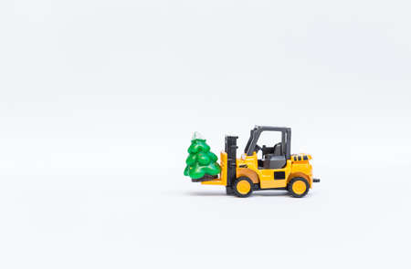 Christmas time concept, truck moving Christmas tree toy on white backgroundの写真素材