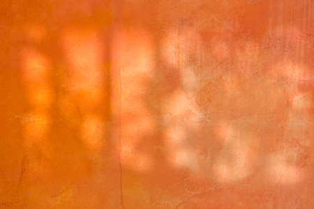 Orange cement wall texture background, morning sun light on blank orange concrete wall backgroundの写真素材