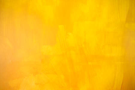 Abstract blurred yellow paint on cement wall texture background, blank artistic yellow backgroundの写真素材