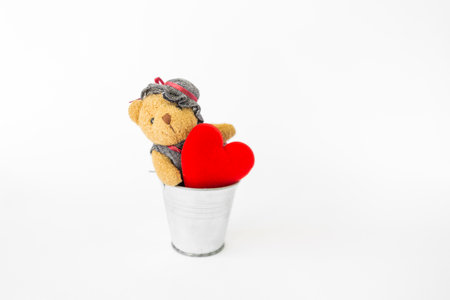 Cute little teddy bear doll with red heart in tin bucket isolate on white background, decorate item for valentine, love and romance, valentine card background ideaの写真素材