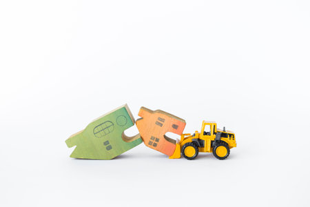 Two wooden house model with front loader truck isolate on white background, clearance sale, property and real estate business industry conceptの写真素材