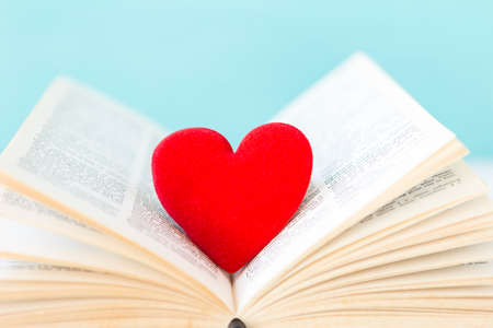 Red heart on old english book with space on blurred blue background, valentine card background idea, love and romance, weddingの写真素材