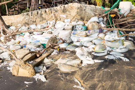 Coastal erosion threatens, Sand bag  and dead tree on the beach in south of Thailand, seashore...