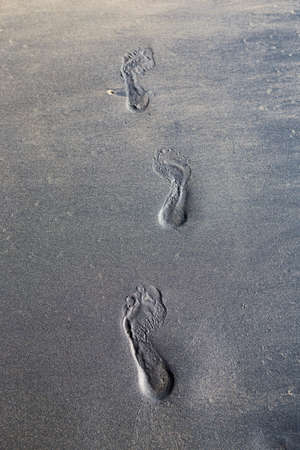 Foot print on Black sand beach background, Khao Lak, south of Thailand, Nang Thong beach, vertical styleの写真素材