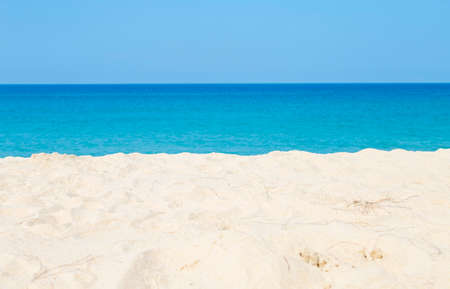 Empty white sandy beach over blurred blue sea and clear sky background, nature background, tropical...