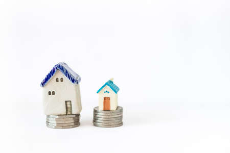 Miniature vintage house on coin stack isolate on white background, buy new house, property and real estate businessの写真素材