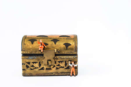 Miniature worker with vintage treasure box on white background, safety box, security and insurance...
