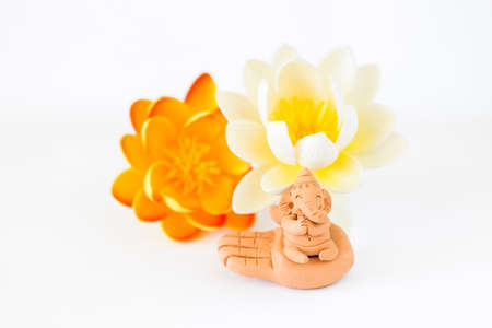 Lord Ganesha clay sculpture with lotus flower on white background, Hindu lordの写真素材