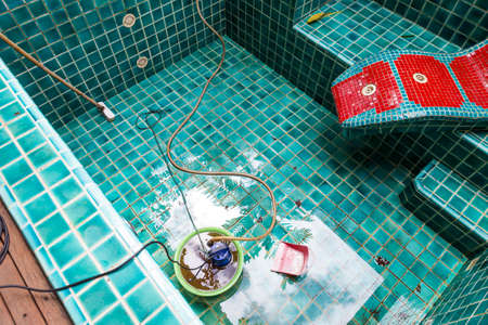 Swimming pool cleaning in rainy season, rain water watch out dirt from roof into swimming pool, pool design problem, remove water from spa poolの写真素材