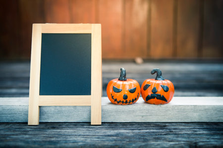 Halloween concept background, Blank chalkboard with funny halloween pumpking with space on wooden wall, vintage filter