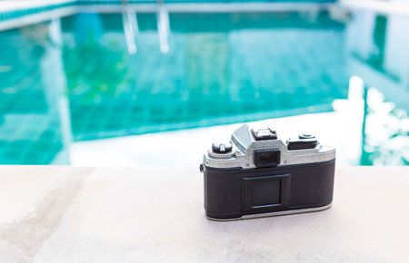 Old camera on swimming pool edge, tourist industry conceptの写真素材