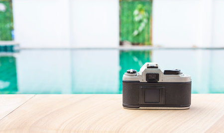 Old camera on swimming pool edge, tourist industry conceptの写真素材