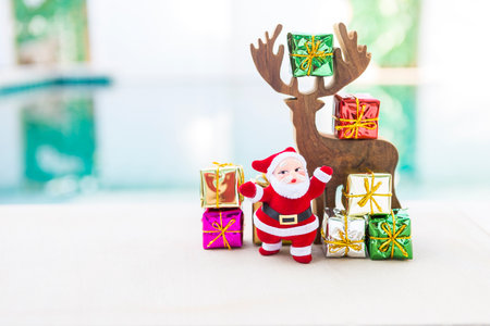 Wooden reindeer with santa claus and colorful gift box over blurred background, Christmas and New...