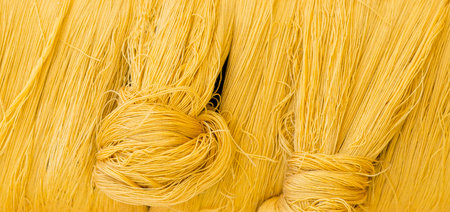Closeup yellow cotton thread background, textile industry concept, product of Thailand