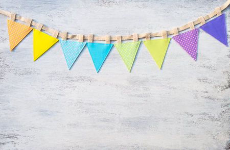 Colorful fabric bunting flag on white wood texture background, celebration or festival background ideaの写真素材