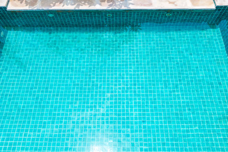 Swimming pool with blue tile and clear water, summer outdoor day light, architecture and...