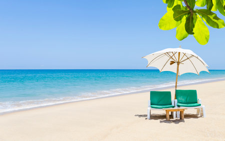 Tropical summer beach background, beach chair with white umbrella on clean sandy beach in south of Thailand, summer outdoor day lightの写真素材
