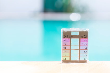 Mini water tester test kit for measuring pH and chlorine on swimming pool edge with space on blurred pool water background, high quality water tester product for safety waterの写真素材