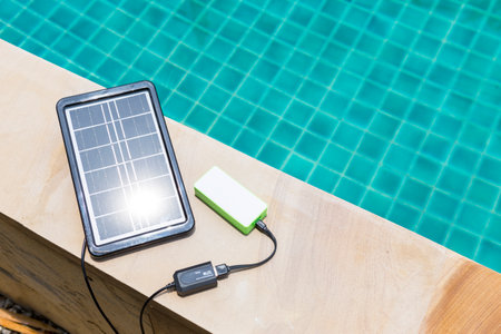 Portable solar cell panel with space on pool water background, clean energy concept, sustainability,...
