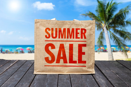 Summer sale jute bag over blurred tropical beach background, end of summer sale conceptの写真素材