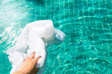 Laundry in swimming pool, bleaching white fabric with swimming pool chemicalの写真素材