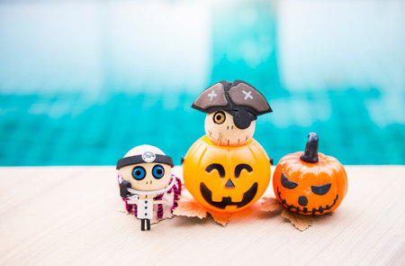 Little doctor ghost wooden doll in Halloween lantern and doctor ghost on swimming pool edge, outdoor day light, Halloween background ideaの写真素材