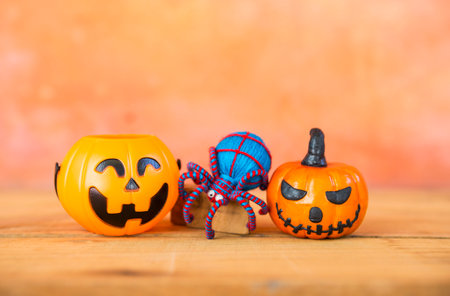 Halloween pumpkin with blue yarn spider over blurred space on orange cement wall, Happy halloween card background ideaの写真素材