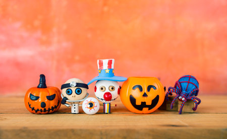 Happy Halloween card background idea, Halloween decoration collections with space on orange cement wall, ghost wooden doll and yarn spider with funny face pumpkinの写真素材