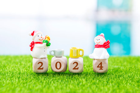 Happy Christmas and New year 2024 concept, wooden cube with number and snowman with coffee cup on...