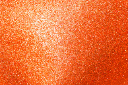 Abstract blurred orange glitter texture background, shiny orange glitter backgroundの写真素材