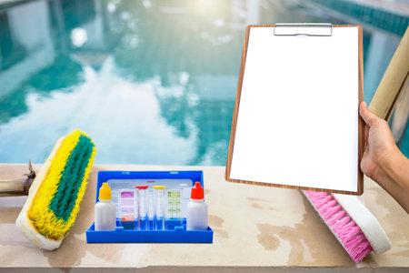 Blank report paper sheet on wooden clipboard and water testing test kit with old two plastic brush...