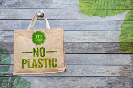 Jute bag with go green logo on wood background with leaves pattern, eco grocery bag with space on old wood wall backgroundの写真素材