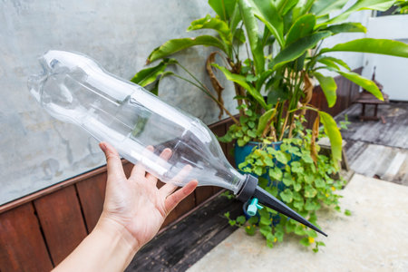Garden watering spike with recycle plastic water over blurred plant pot, automatic garden watering systemの写真素材