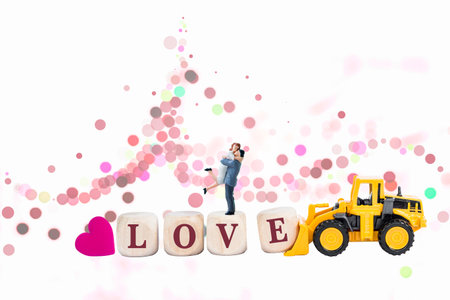 Miniature couple on love wooden cube with yellow truck on abstract background, love and romance,...