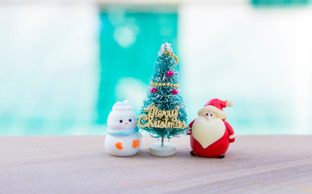Miniature Santa and Snow man with Christmas tree with space on blurred background, Chirstmas card background ideaの写真素材