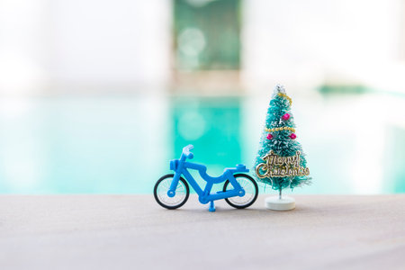 Blue toy bicycle with Christmas tree over blurred background, Christmas background ideaの写真素材