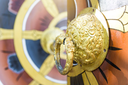 Traditional Bhutan Door Knocker, closeup door knocker paint in gold on design wooden doorの写真素材