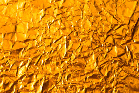 Abstract crumpled gold paper texture background, blank wrinkle paper pattern backgroundの写真素材