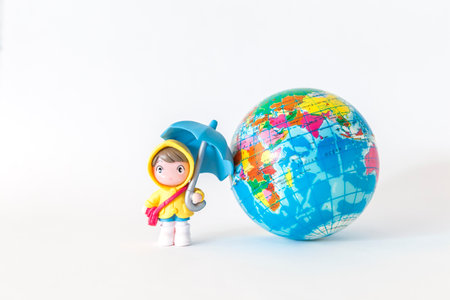Miniature boy and blue umbrella with globe isolate on white background, world weather forecastの写真素材