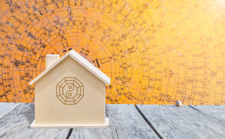 Miniature with Feng Shui symbol on wooden table over ancient wooden Chinese compass background, buy new house, property and real estate business conceptの写真素材