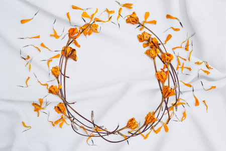 Dry yellow flower arrange in round shape frame on white fabric background, flower card backgroundの写真素材