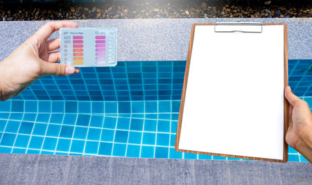 Water tester test kit with blank report on wooden clipboard over clear swimming pool water background, outdoor resort pool, pool design, clean and crystal clear swimming pool waterの写真素材