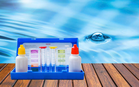 Water tester test kit on wooden table over blurred swimming pool water background, quality water testing test kit, pool maintenance and service business conceptの写真素材