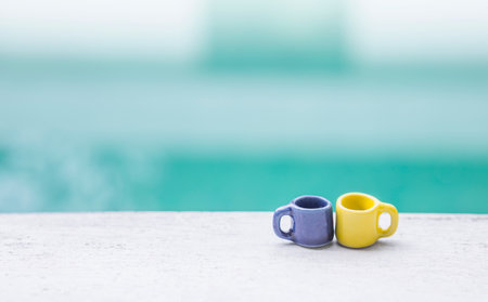 Blue and yellow ceramic cup with space on blurred background, outdoor day light, easy life style, relaxing morningの写真素材