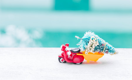 Red scooter with Christmas tree over blurred background, Christmas card background ideaの写真素材