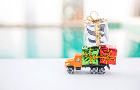 Colourful gift box on orange truck over blurred background, Christmas and New year gift deliveryの写真素材