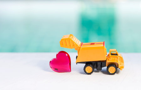 Dump truck with red heart over blurred background, dump love, love and romanceの写真素材