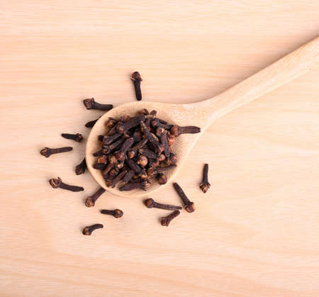 Spice cloves in spoon on wood background ; spice is herb for health and  Aromatherapy .の写真素材
