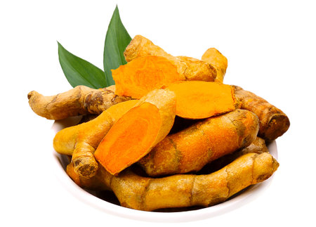 Turmeric (Curcumin) powder in white bowl with rhizome isolated on white background.の写真素材